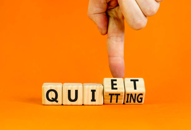 Quiet quitting symbol. Concept words Quiet quitting on wooden cubes. Businessman hand. Beautiful orange table orange background. Business quiet quitting concept. Copy space. stock photo