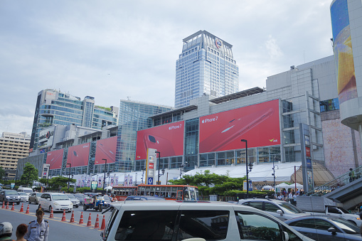 Centralworld shopping mall in Bangkok downtown with huge red Apple iPhone  at facade. Mall is in Ratchadamri Road. On street is traffic jam