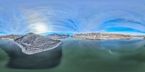 Aerial 360-degree panoramic view of Deer Creek Reservoir and Mt Timponogos in Provo, UT on a sunny winter day
