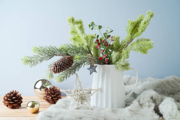 istock Christmas table decoration with pine tree branches in vase and ornaments over bright background 1446519667
