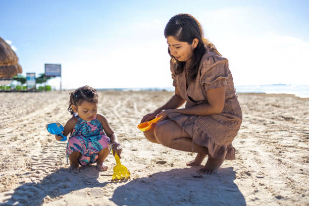 istock Mother and daughter playing on the beach 1446524696