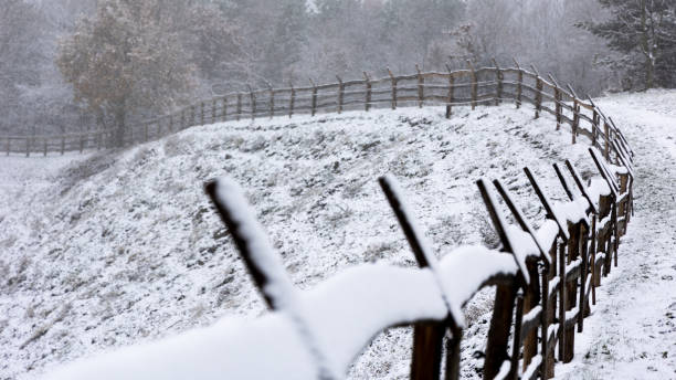 istock Wooden fence covered with a thin layer of the first snow. 1446528207