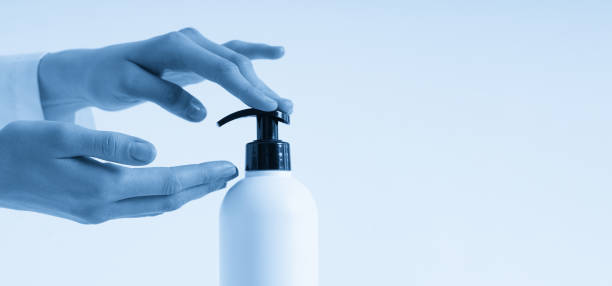 istock Woman hands pushing pump plastic soap bottle with copy space, using wash hand sanitizer gel pump dispenser. killing germs, bacteria and virus 1446529333