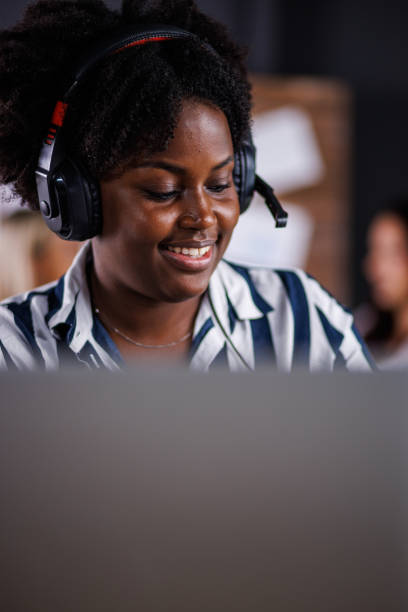 istock Charming young woman wearing a headset and video conferencing a client 1446529664