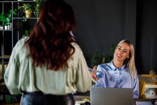 istock Young woman handing her coworkers some project documents 1446529852
