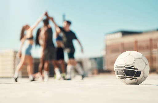 Soccer sports, team building and high five between friends on rooftop in city. Diversity, fitness men and healthy women lifestyle cardio wellness training or support motivation together in urban town