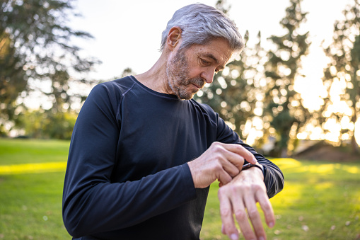 A senior man using a smart watch for fitness during a workout.