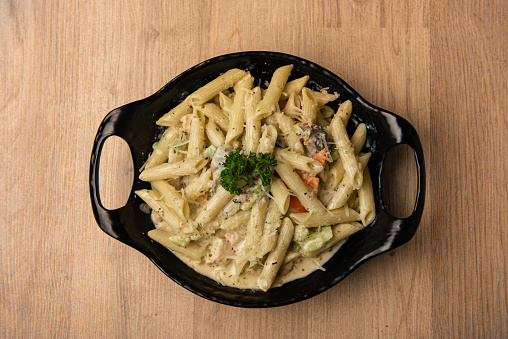 Pasta with white sauce served in dish isolated on table top view of arabian food