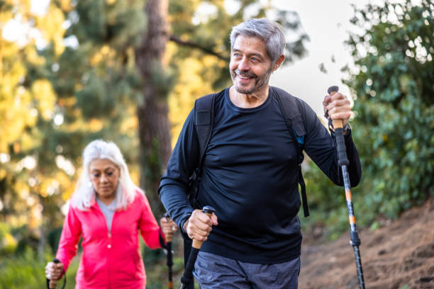 Senior couple hiking in mountain with redwood trees A senior couple hiking in the mountain with redwood trees body positive couple stock pictures, royalty-free photos & images