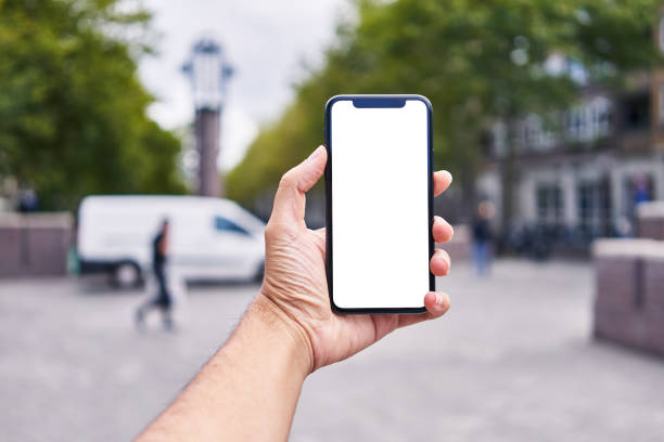 istock Man holding smartphone showing white blank screen at amsterdam 1446540398