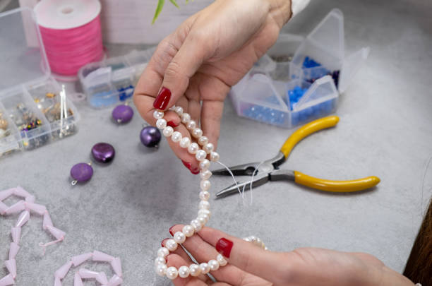 istock Close hand jeweler stringing pearls on a necklace 1446540495