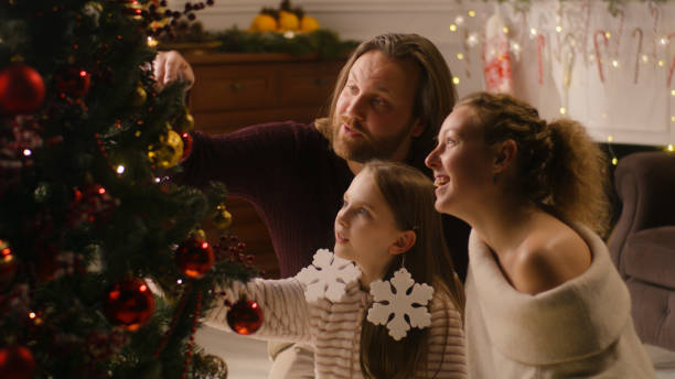istock Family decorating Christmas tree with branches 1446540764