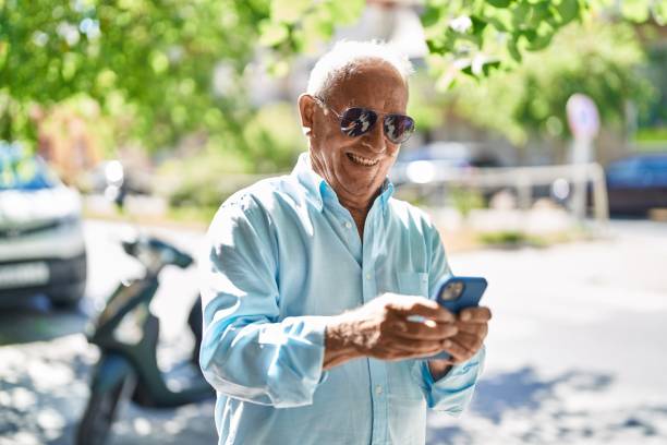 istock Senior grey-haired man smiling confident using smartphone at street 1446542414