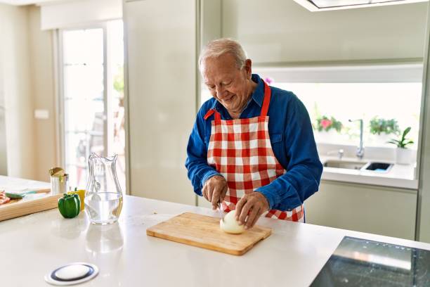 istock Senior man smiling confident cutting onion at kitchen 1446542470