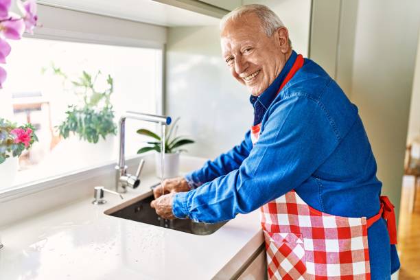 istock Senior man smiling confident washing hands at kitchen 1446542480