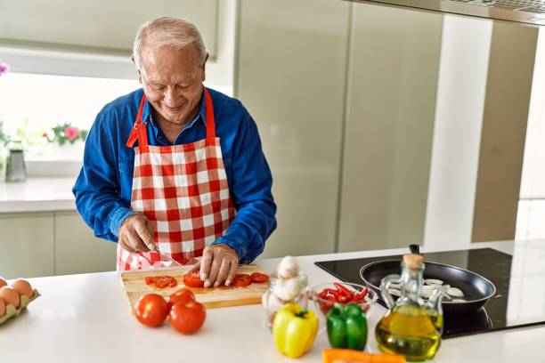 istock Senior man smiling confident cutting tomato at kitchen 1446542481