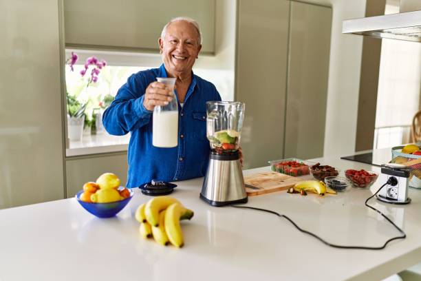 istock Senior man smiling confident pouring milk on blender at kitchen 1446542490