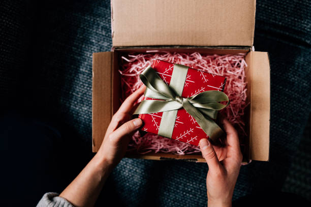 istock Hands of a Woman Unpacking a Wrapped Present 1446544101