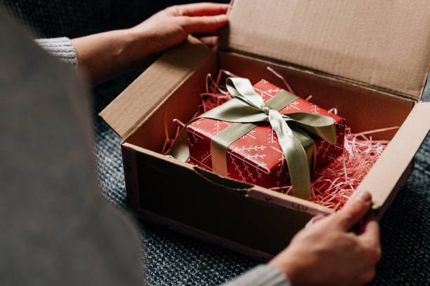 istock Hands of a Woman Unpacking a Wrapped Present 1446544102