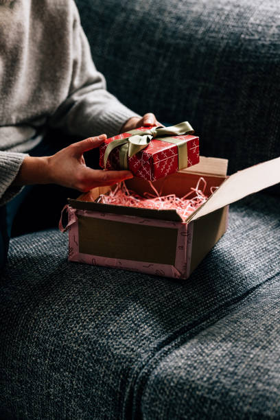 istock Hands of a Woman Unpacking a Wrapped Present 1446544103