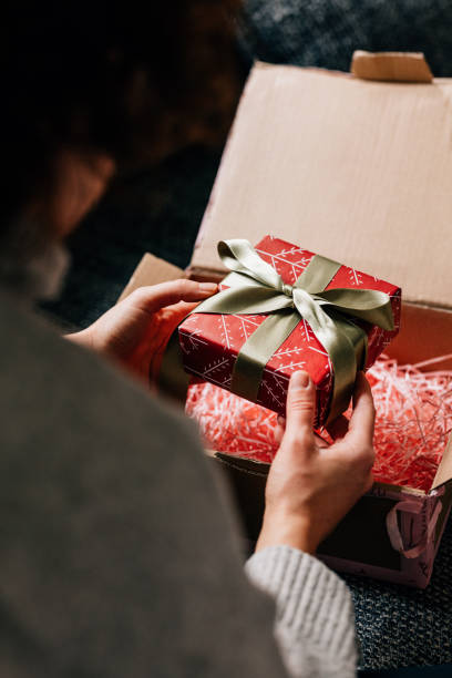 istock Hands of a Woman Unpacking a Wrapped Present 1446544120