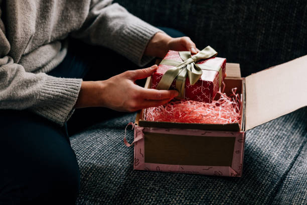istock Hands of a Woman Unpacking a Wrapped Present 1446544123