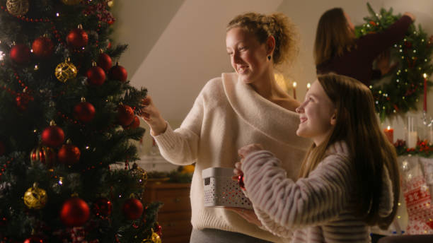 istock Daughter with mom decorating Christmas tree 1446544210