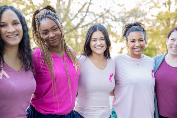 diversas mulheres de todas as idades participam juntas de eventos de caridade de conscientização sobre o câncer de mama para arrecadar dinheiro para a cura - outubro rosa - fotografias e filmes do acervo
