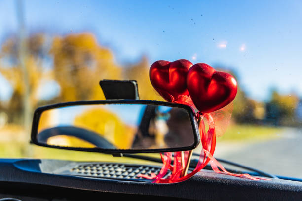 istock Small rear view car mirror with two red hearts behind 1446556009