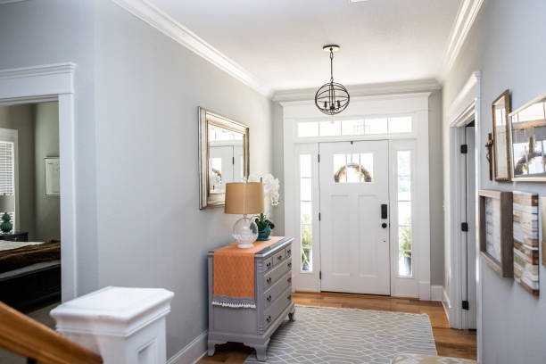 an open large and wide interior front door hallway foyer with transom, hanging light fixture, coastal colors and entry way table and wood floors - house indoors lighting equipment ceiling imagens e fotografias de stock