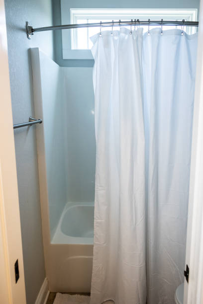 istock a small bathroom with a bathtub shower insert with a hanging white shower curtain 1446557613