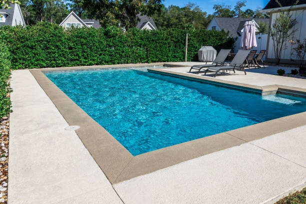 istock A rectangular new swimming pool with tan concrete edges in the fenced backyard of a new construction house 1446558666