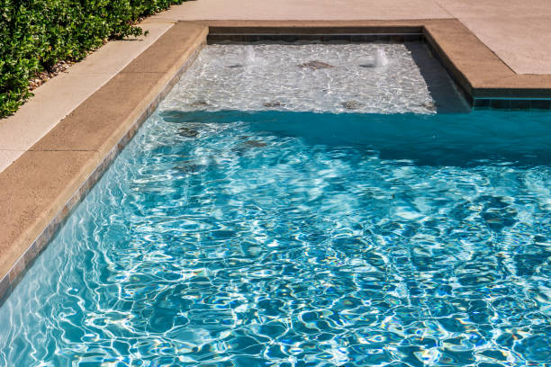 istock A rectangular new swimming pool with tan concrete edges in the fenced backyard of a new construction house 1446558697