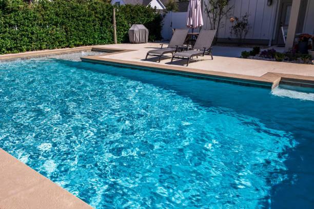 istock A rectangular new swimming pool with tan concrete edges in the fenced backyard of a new construction house 1446558722