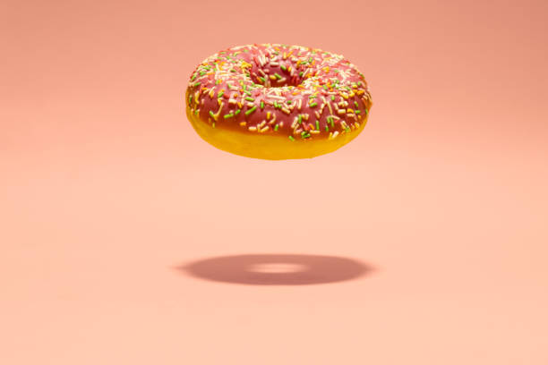 istock Levitating pink donut on pink background. Creative food background. Minimal wallpaper 1446558805