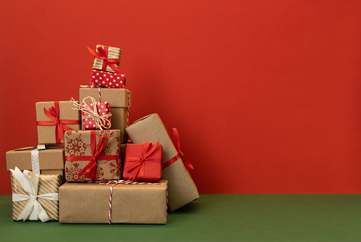 pile of craft wrapped christmas gifts on red background. High quality photo