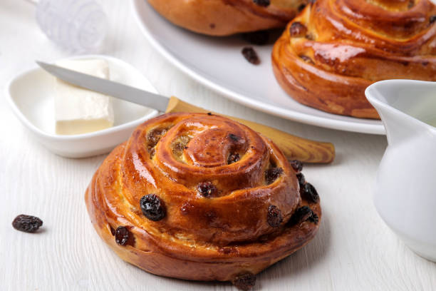 istock Tasty buns with raisins and butter on a white wooden table. fresh bakery. breakfast. bread. close-up 1446570708
