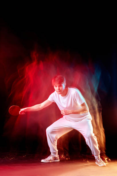 istock young man playing table tennis in mixed neon light 1446570903