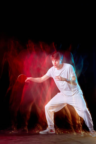 istock young man playing table tennis in mixed neon light 1446570906