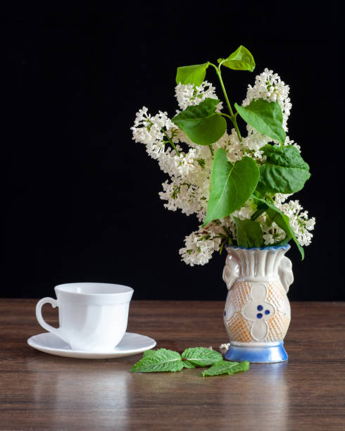 istock There is a white lilac in a vase on the table. 1446575484