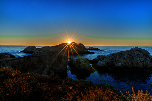 Sunset on top of rock beside 17 mile drive