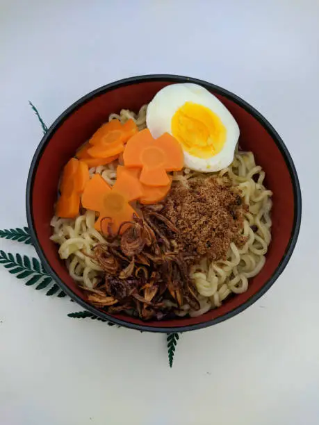 Photo of a bowl of delicious noodles on a white background