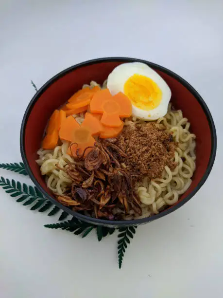 Photo of the noodles are in a black bowl with a white background