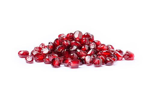 Pile of red pomegranate seeds isolated on white background.