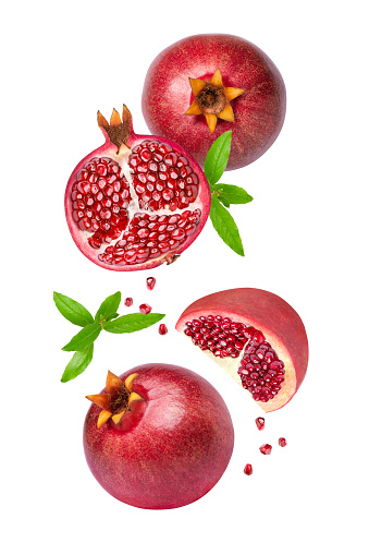 Pomegranate with seeds and half slice levitate isolated on white background.