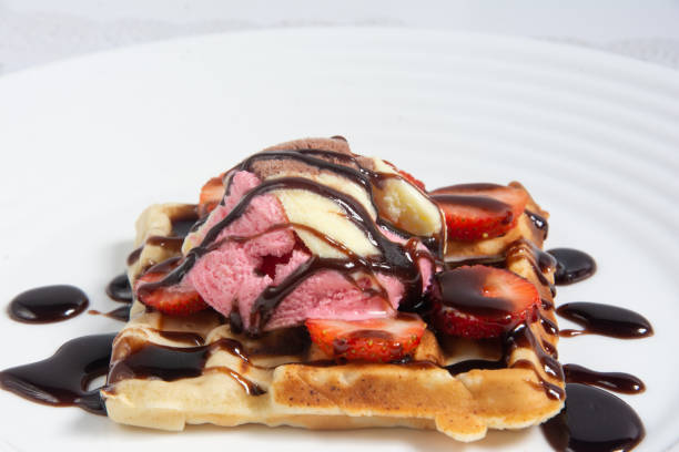 Delicious wafle with ice cream and chocolate syrup on a white dish