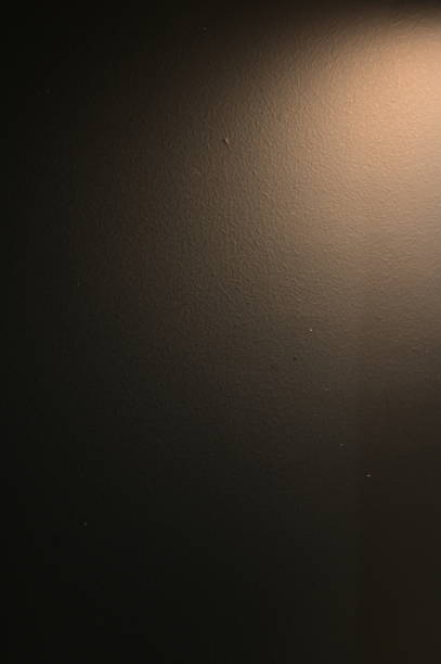 istock brown wall background with lights and black shadow 1446600023