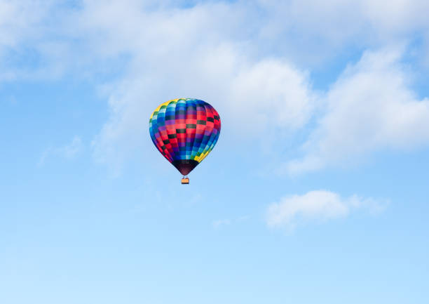 Colorful hot air balloon flying in the blue sky with soft clouds - at Winthrop Balloon Festival, Washington state stock photo