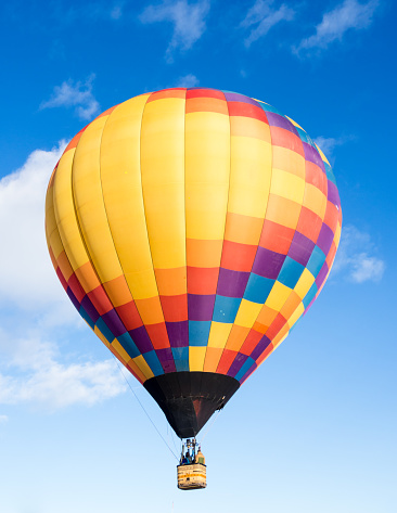 Colorful hot air balloon flying in the bright blue sky during Winthrop Balloon Festival in Washington state