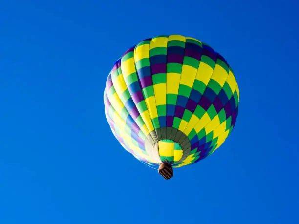 Colorful hot air balloon flying in the bright blue sky during Winthrop Balloon Festival in Washington state